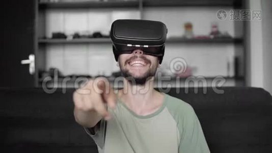 年轻的大胡子嬉皮士开始使用他的VR耳机显示器与耳机虚拟现实游戏或观看视频