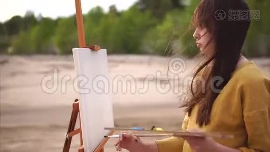 这位年轻的艺术家在画布上画了第一笔静物画视频