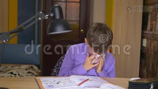 一个生病的男孩坐在家里的桌子旁，把鼻子吹成餐巾视频