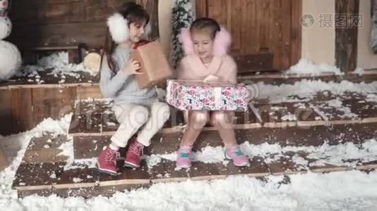 圣诞节或新年。 孩子们交换圣诞礼物。 两个小女孩在新年的背景`视频