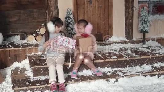 圣诞节或新年。 孩子们交换圣诞礼物。 两个小女孩在新年的背景`视频