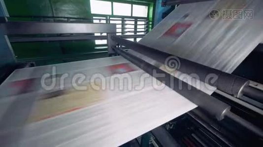 印刷设备在工厂的生产线上移动纸张。 4K.视频