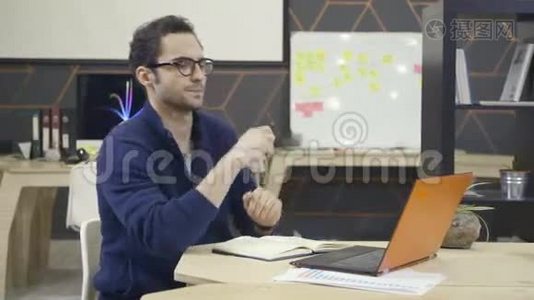 工作场所使用笔记本电脑戴眼镜的创意人视频