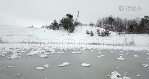 冰雪覆盖的池塘和白雪覆盖的植物。 冬季景观。视频