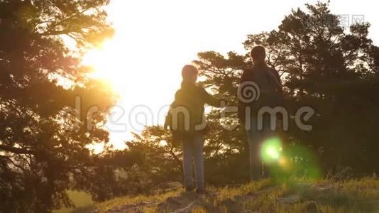 女孩带着背包在乡村公路上旅行。 徒步旅行者女孩。 两个女孩旅行，穿过森林，挥动双手视频