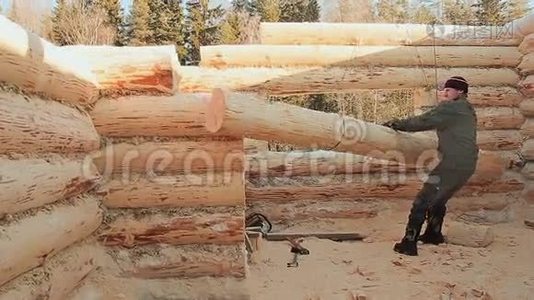 木匠指示用起重机吊起原木。 加拿大角砌体。 加拿大风格。 木头做的木屋。视频