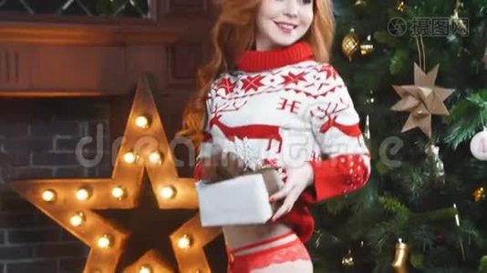 快乐的红发女孩穿着红色毛衣，拿着圣诞礼物，微笑着。视频