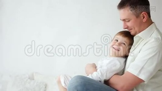 儿子在家里和爸爸在床上玩视频