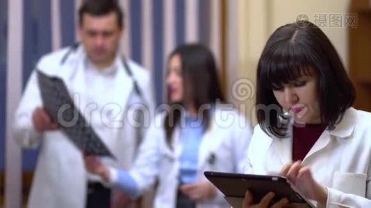 一位女医生手里拿着一块药片。 在背景中，医生检查x光..视频