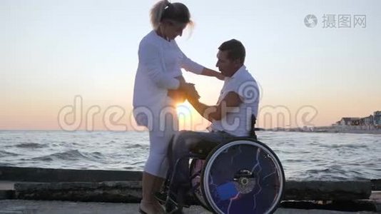 残疾配偶在轮椅上与怀孕女性在日落时，残疾男子在轮椅上抚摸妇女视频