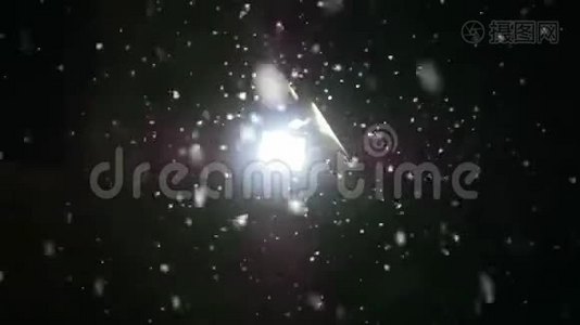 雪在夜间冬天慢慢落下。 灯笼在雪地里闪闪发光。 慢动作视频