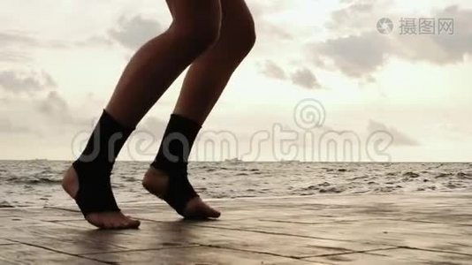 女拳击手在训练中`腿向前移动. 女人在海滩边训练。 双腿特写。 慢镜头视频