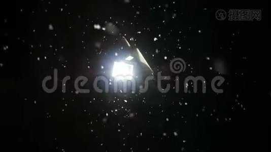 雪在夜间冬天慢慢落下。 灯笼在雪地里闪闪发光。 慢动作视频