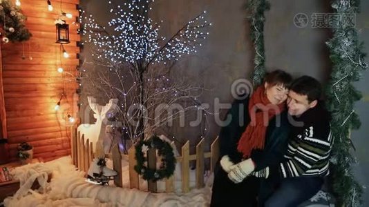 一对相爱的夫妇在童话装饰的背景下互相欣赏。 圣诞节和新年主题。视频