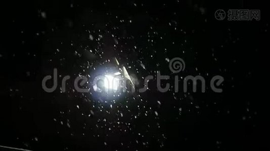 雪在夜间冬天慢慢落下。 灯笼在雪地里闪闪发光。 慢动作视频