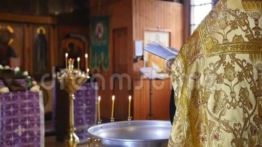 圣父在洗礼仪式之前在教堂里念祈祷。 东正教教堂的秘密洗礼仪式视频