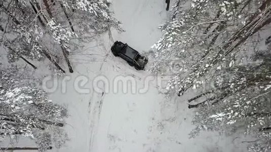 一辆6x6越野车的鸟瞰图，站在冬天森林里白雪覆盖的道路上视频