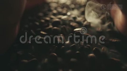 香喷喷的烤咖啡豆从人手里溅出来.. 慢运动中的芳香烟雾和棕色背景视频
