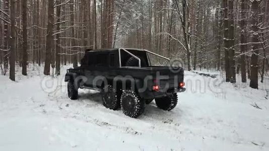 越野车6x6站在冬季森林积雪的道路上，鸟瞰视频