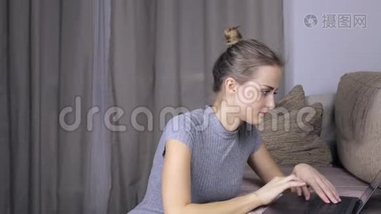 快乐的女人在家里用她的笔记本电脑。 女人在电脑上打字视频