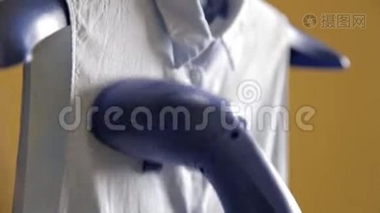 女人用蒸汽熨她的衬衫。 用蒸汽清洁剂蒸衬衫的过程。 关门视频