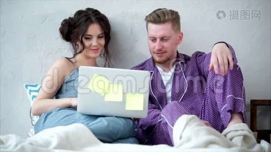 年轻夫妇一起看系列节目，在床上聊天。视频