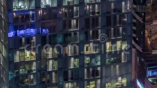 外部公寓塔楼时间推移夜景。 高耸的摩天大楼，窗户闪烁着灯光视频