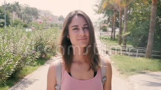 热带度假胜地夏季炎热的城市街道上年轻漂亮女子的肖像视频