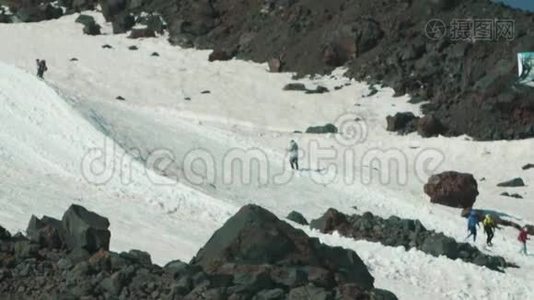 人们登山游客在雪山山坡上漫步视频