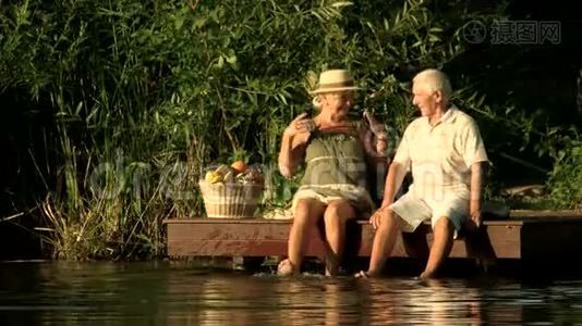 坐在湖边的老夫妇。视频