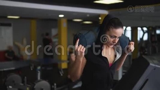 这位女运动员在跑步机上踏着一个负重的舞步.视频