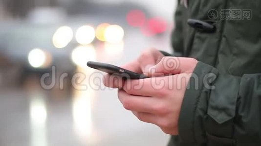 一个年轻人在街上使用他的智能手机。视频