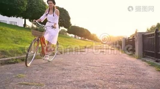 日落时骑自行车的年轻美女。 不同速度拍摄的视频视频