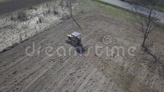 一名农民在一辆拖拉机上，带着播种机在村庄地区的一个私人田地里播种谷物。 弹簧场的机械化视频
