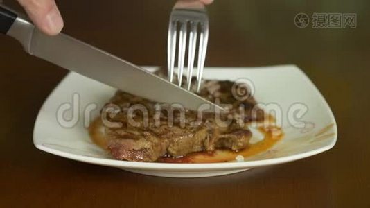 关闭锁定的牛排。 手拿刀叉，从盘子里拿出一部分肉牛排..视频