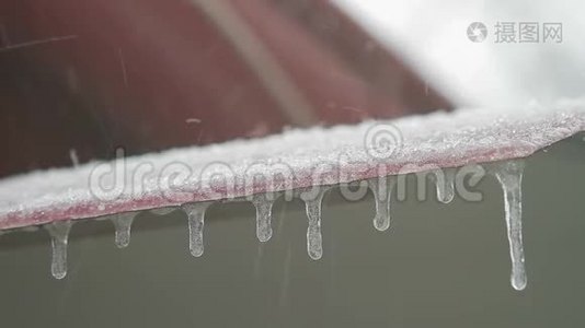 房子的屋顶在暴风雪中。 雪落在石板上视频