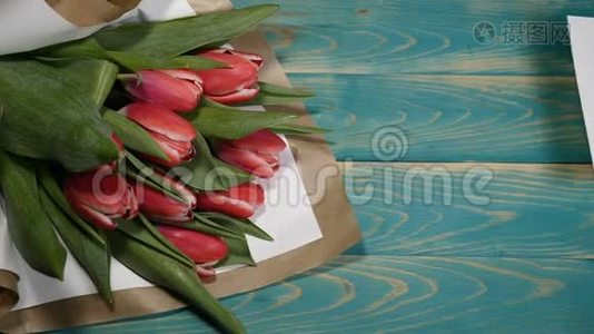 您可以在木桌上看到一张留言条和郁金香花束。 夫妻关系的概念。 圣士视频