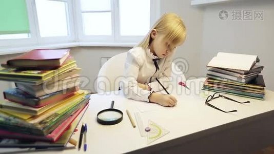 一个可爱的金发女孩在练习本里画画。视频