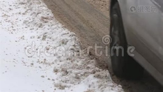 肮脏的冬天道路上有水坑和雪。视频