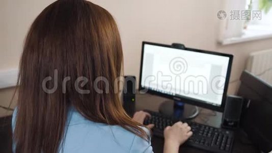 女商人黑发女人坐在办公室，在电脑键盘上打字。视频