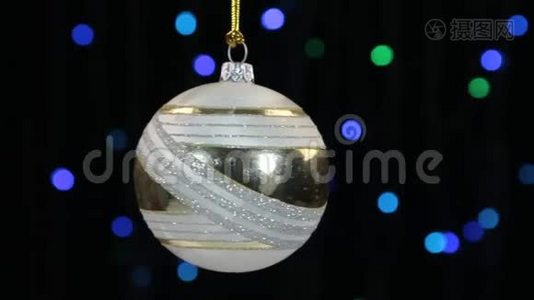 白色圣诞球摆动在离焦背景与闪烁的花环灯。视频