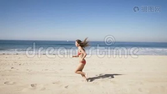 快乐的年轻女子在加州曼哈顿海滩跑步。 夏季视频