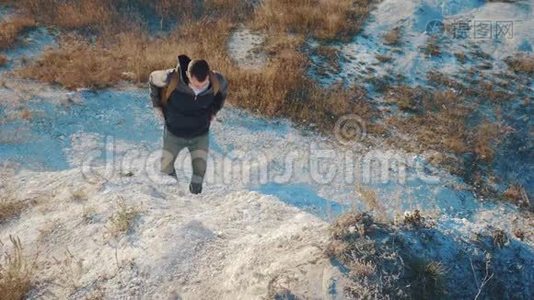 徒步旅行者登山者背着背包在山上徒步旅行。 带着沉重的背包在日落山上徒步旅行视频