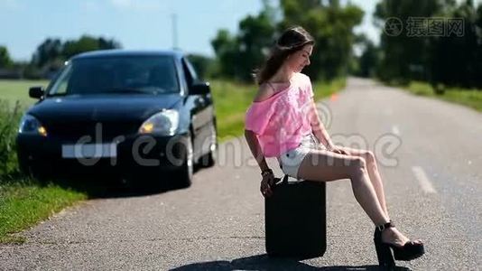 可爱的女人坐在乡村路上的罐子里视频