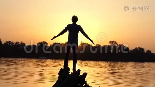 快乐的人站在湖边的树根上视频