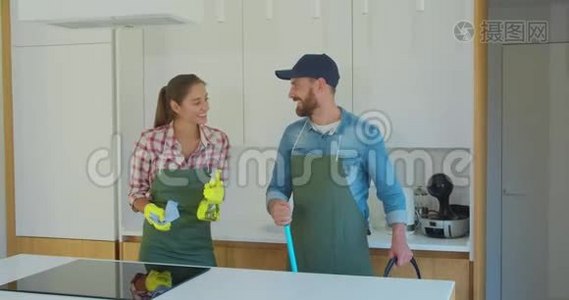 一对夫妇的肖像，作为一名职业清洁工，穿着制服，站在一起，在室内使用清洁工具。视频