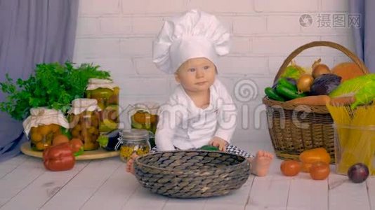 一个可爱的小男孩在厨房里玩新鲜蔬菜。视频