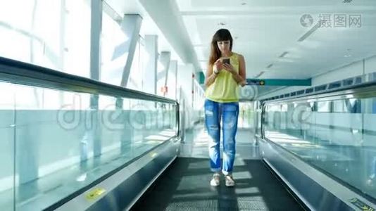 站在自动人行道上的女人，站在地铁口的楼梯上，用她的电话，一种交流的手段，一种时尚视频