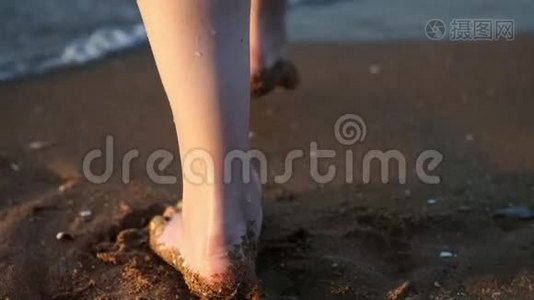 结束：女性或女孩的脚踩在贝壳上的黄沙上，进入大海。 女孩跳进水里视频
