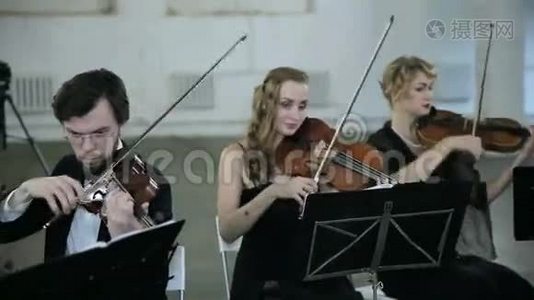 三位小提琴手和指挥演奏音乐视频